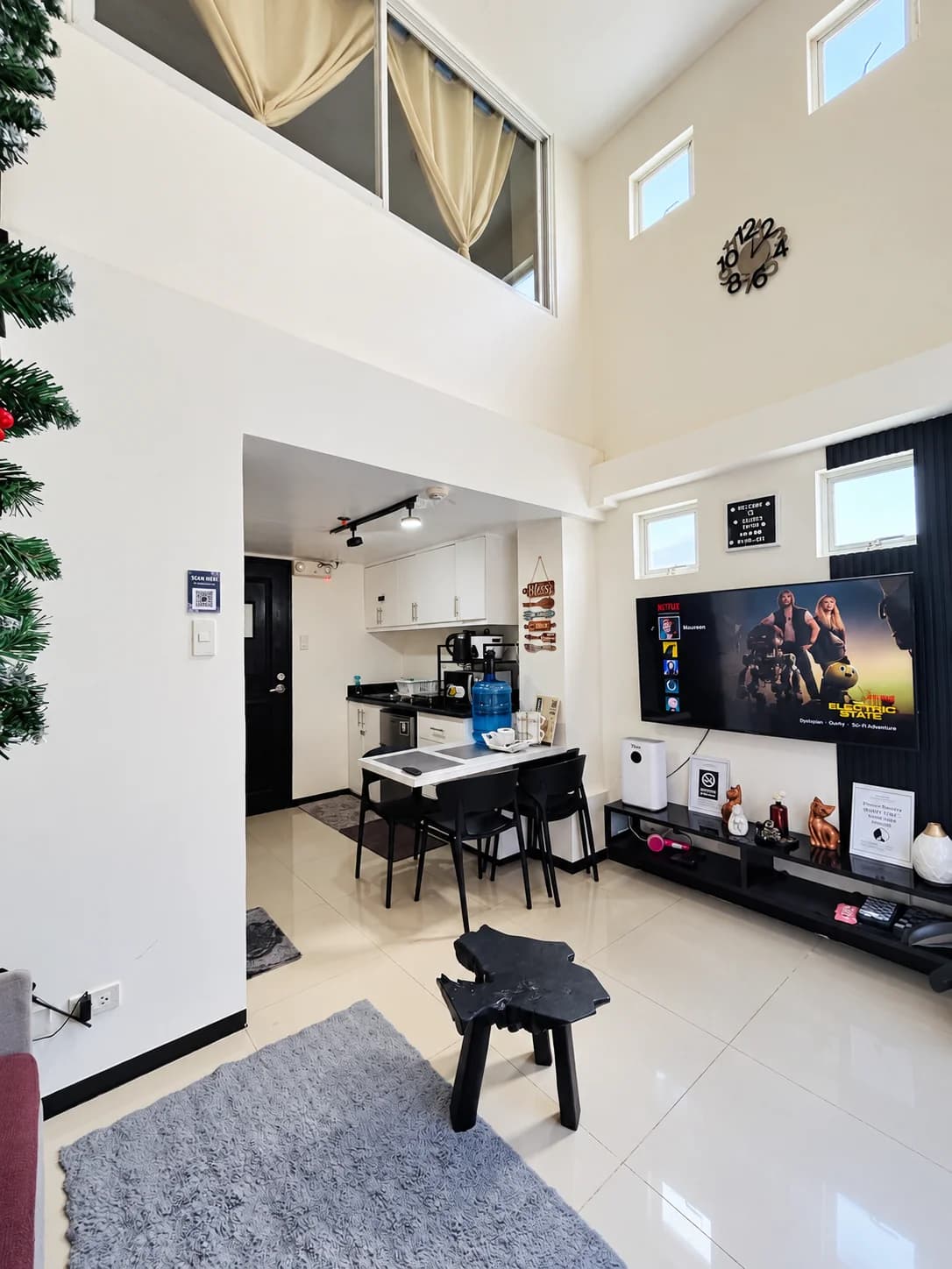 Double-height loft living space with dining table, kitchen and TV